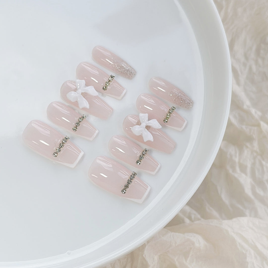 Elegantes Press-On Nagelkunst-Set mit Schleife und Strass-Akzenten