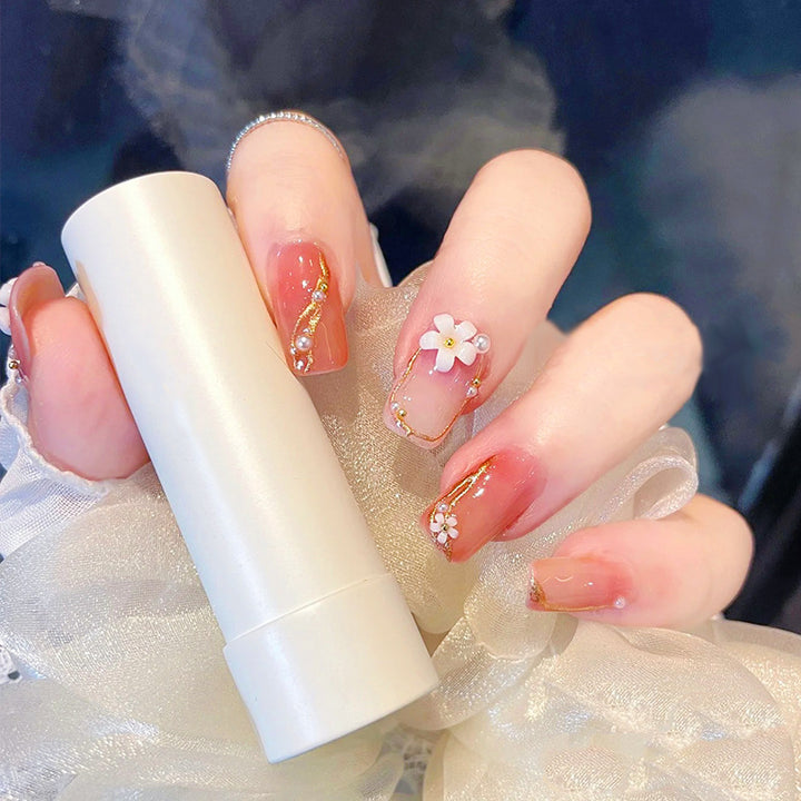 Kunstnagelset mit eleganten Blumendekoren und glamourösen Perlenakzenten Karnz