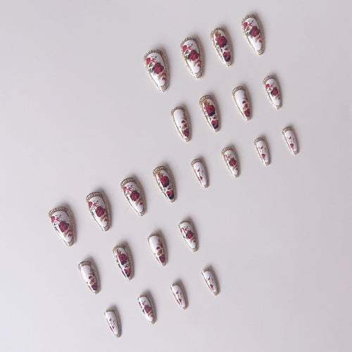 Kunstnagelset mit luxuriösem Blumenmuster und goldenen Akzenten Karnz