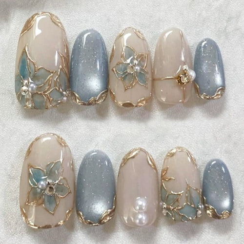 Kunstnagelset mit eleganten Blütenverzierungen und Glanz Karnz