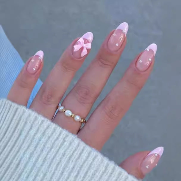 Kunstnagelset mit schimmernden 3D-Schleifen und eleganten Perlenakzenten Karnz