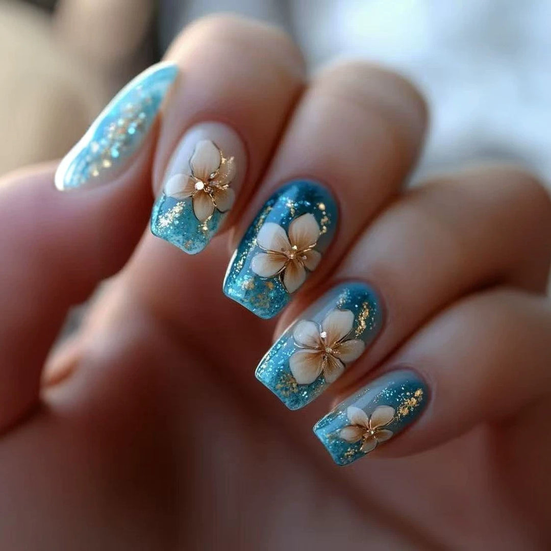Kunstnagelspitzen mit floralen Akzenten und Glitzer Karnz