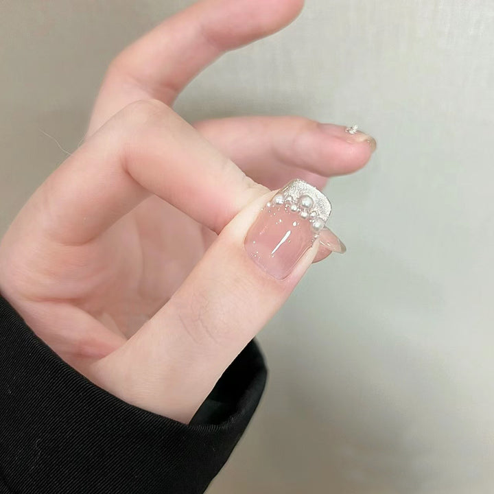 Elegante Kunstnägel mit Perlenschmuck und Glitzereffekten Karnz