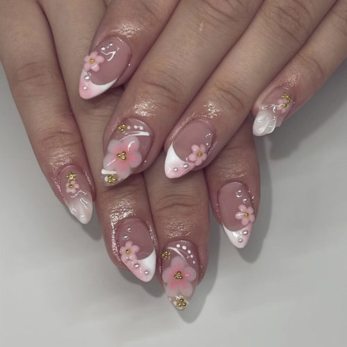 Kunstvolle Nagelverlängerungen mit Blütenmuster und Glitzerakzenten Karnz