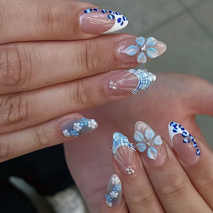 Kunstnagelset mit exquisiten blauen Blüten- und Glitzerverzierungen Karnz