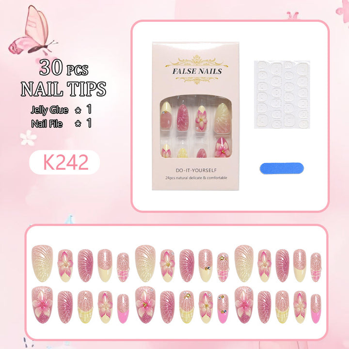 Kunstnagelset mit filigranen Blütenverzierungen und Glitzerelementen Karnz