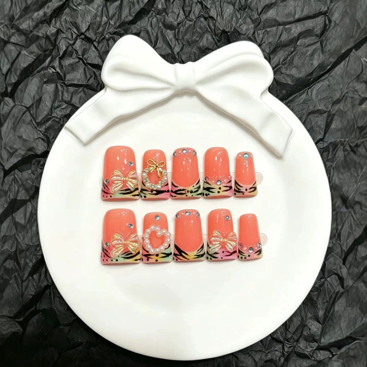 Dekoratives Press-On Nagelset mit eleganten Blumen- und Schleifenakzenten