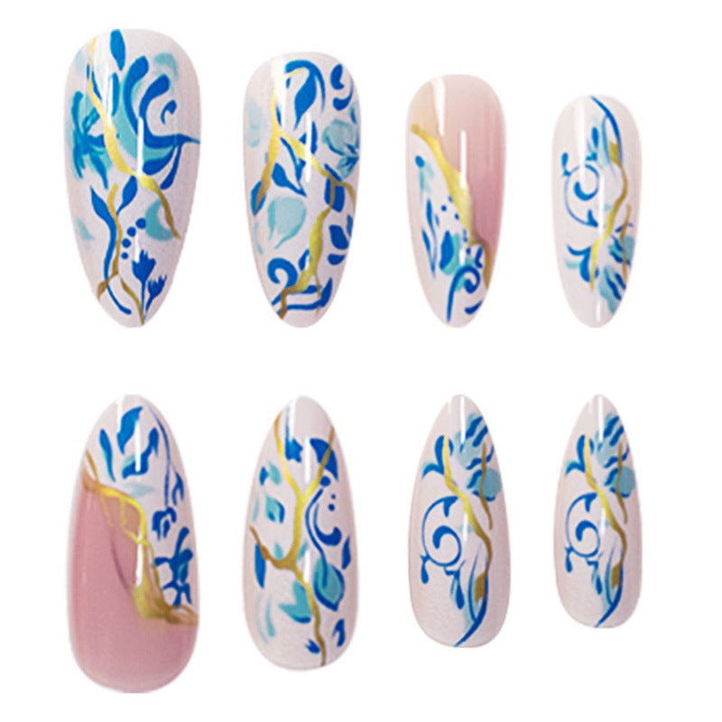 Künstlerisches florales Press-On-Nageldesign mit goldenen Akzenten Karnz