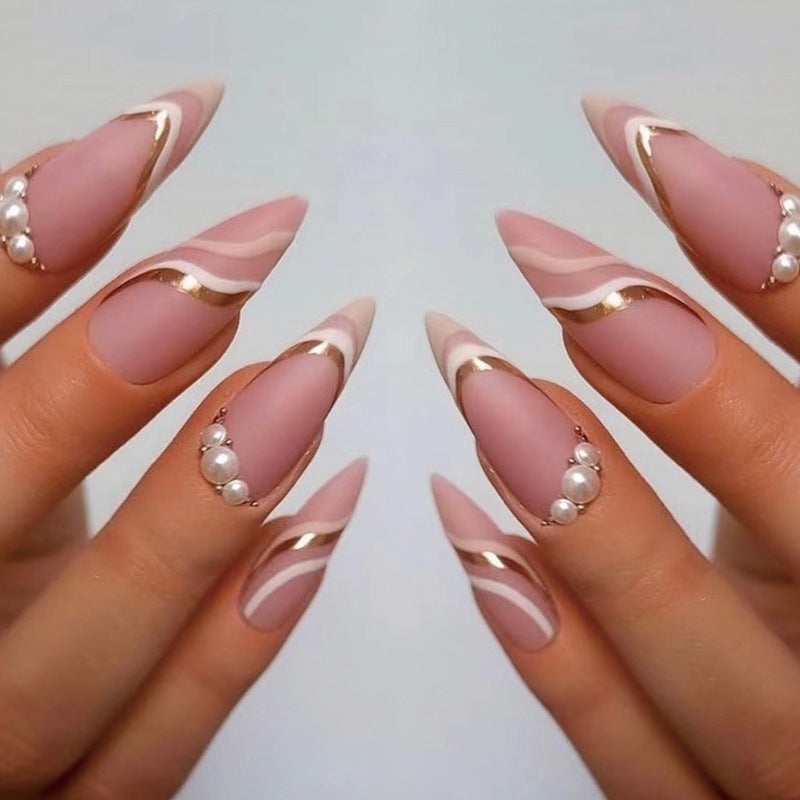 Kunstvolle Stiletto-Nägel mit eleganten goldenen und weißen Akzenten Karnz