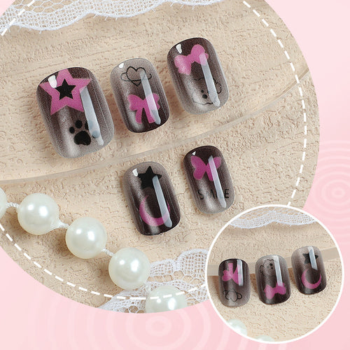 Künstlerisches Press-On Nagelset mit Stern- und Schleifenmotiven