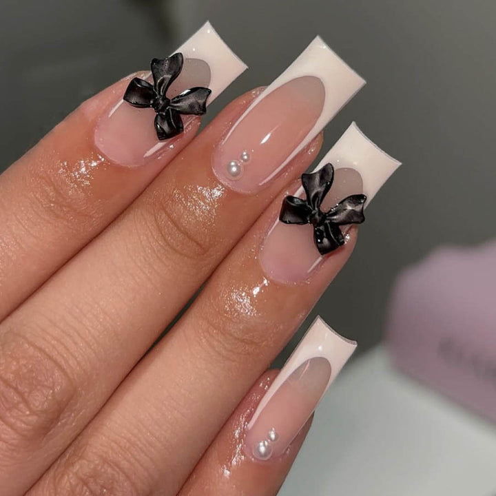 Kunstnagelset mit stilvollen Schwarz- und Perl-Details Karnz