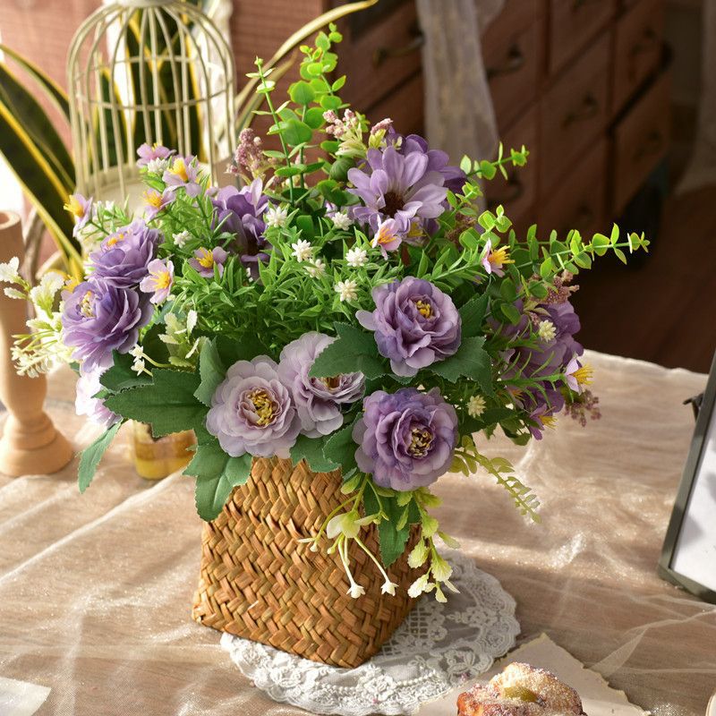 Elegante synthetische Blumenarrangement in geflochtenem Korb