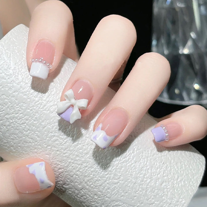 Kunstnagelset mit eleganten Wellenmustern und zarten Perlenakzenten Karnz
