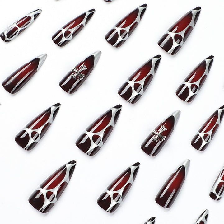 Kunstvolle Stiletto-Nägel mit eleganter Kreuzverzierung Karnz
