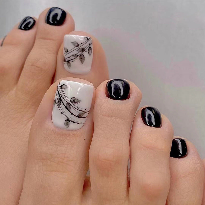 Kunstvolle Fußnagelkunst im eleganten Schwarz-Weiß-Design Karnz