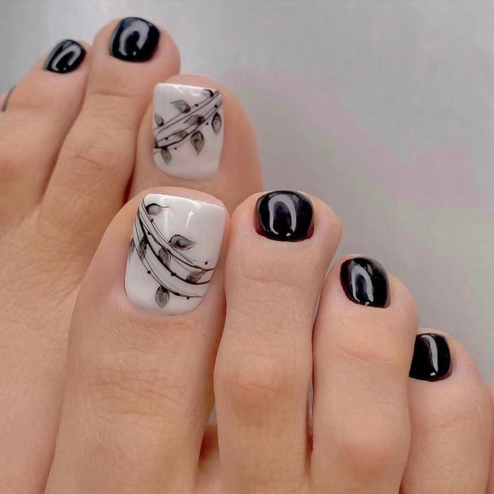 Kunstvolle Fußnagelkunst im eleganten Schwarz-Weiß-Design Karnz
