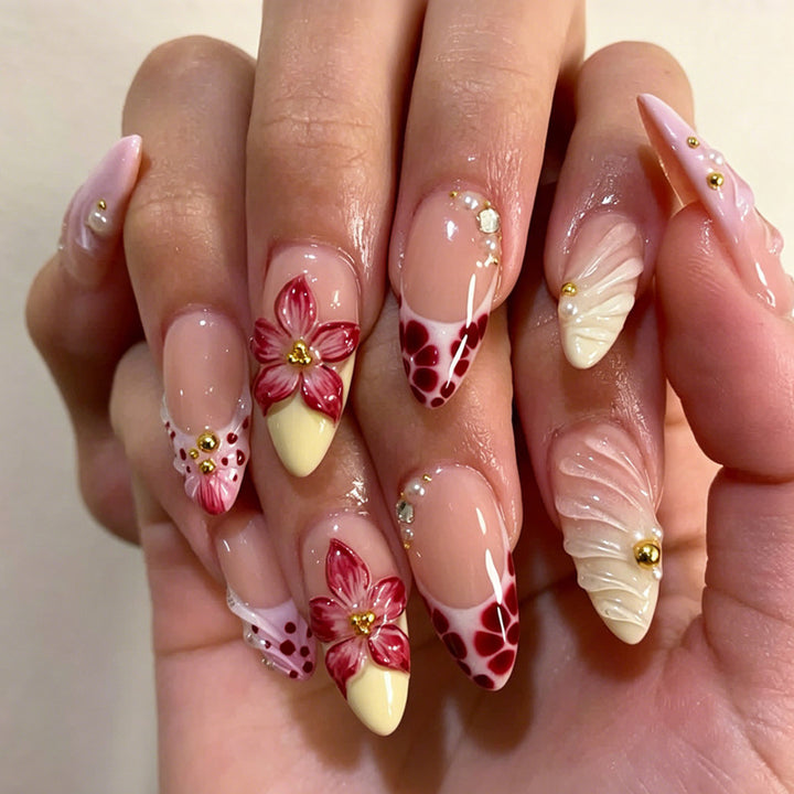 Kunstnagelset mit kreativen floralem Design und glitzernden Akzenten Karnz