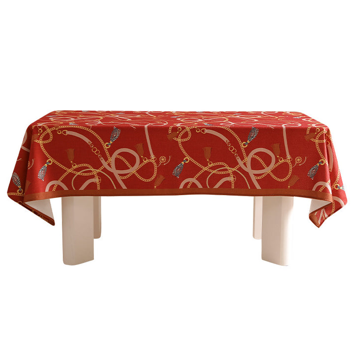 Rechteckige Tischdecke aus pflegeleichtem Polyester‑Mischgewebe mit dekorativem Quasten‑ und Bandmotiv und kontrastierter Saum