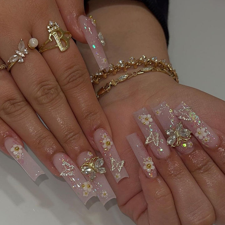 Kunstnagelset mit eleganten 3D-Blüten und Glitzerdetails Karnz