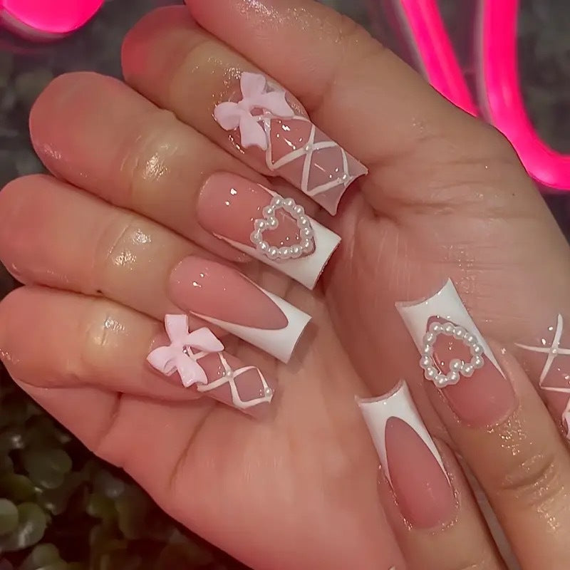 Elegante Kunstnagelspitzen mit Herz- und Schleifenakzenten Karnz