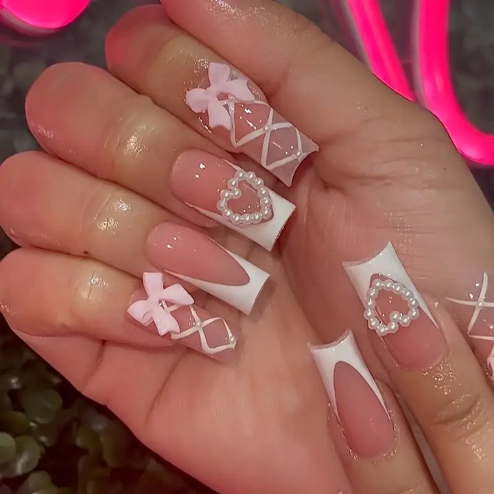 Elegante Kunstnagelspitzen mit Herz- und Schleifenakzenten Karnz