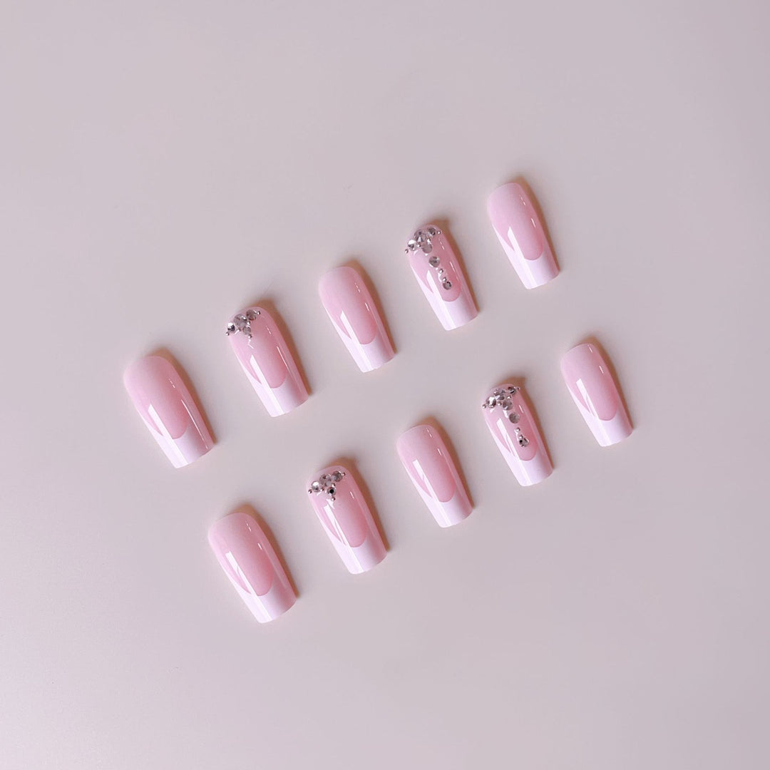Kunstnagelset mit eleganten French Spitzen und funkelnden Strassakzenten Karnz