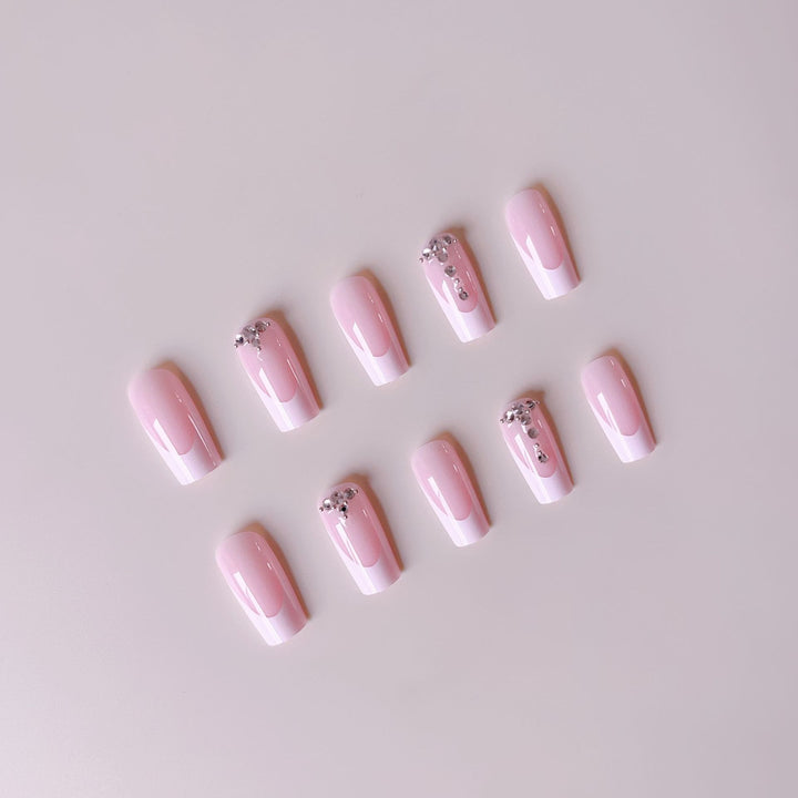 Kunstnagelset mit eleganten French Spitzen und funkelnden Strassakzenten Karnz