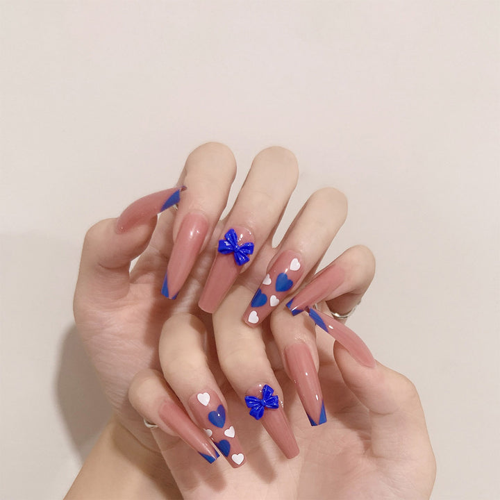 Kunstvolle Stiletto-Nägel mit modernen Herz- und Schleifenmotiven Karnz