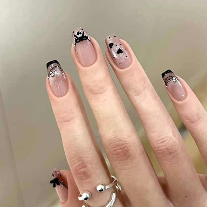 Elegantes kunstvolles Nageldesign mit Schleifen- und Glitzerelementen Karnz