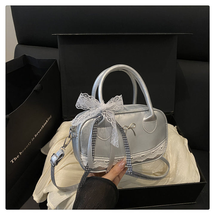 Elegante mit Spitzenbesatz verzierte Bogenhandtasche Karnz