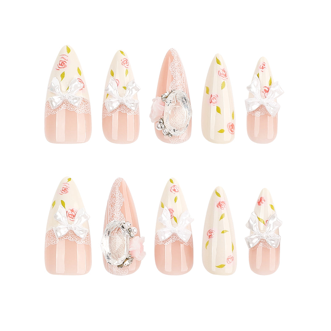 Kunstvolle Stiletto-Nägel mit floralen Akzenten und Glitzerakzenten Karnz