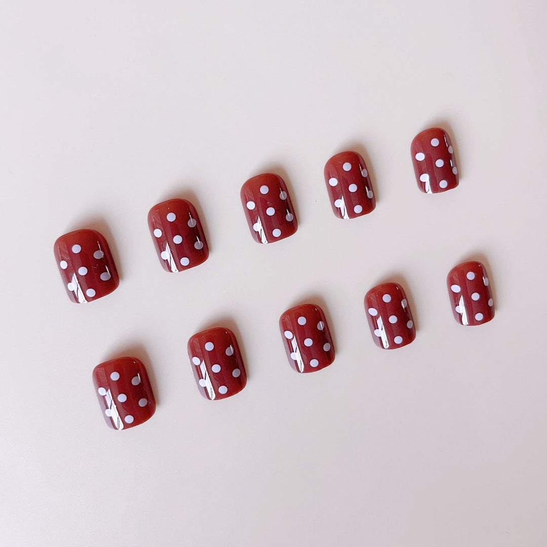 Kunstnagelset mit stilvollen Schokoladenflecken und eleganten Punkten Karnz