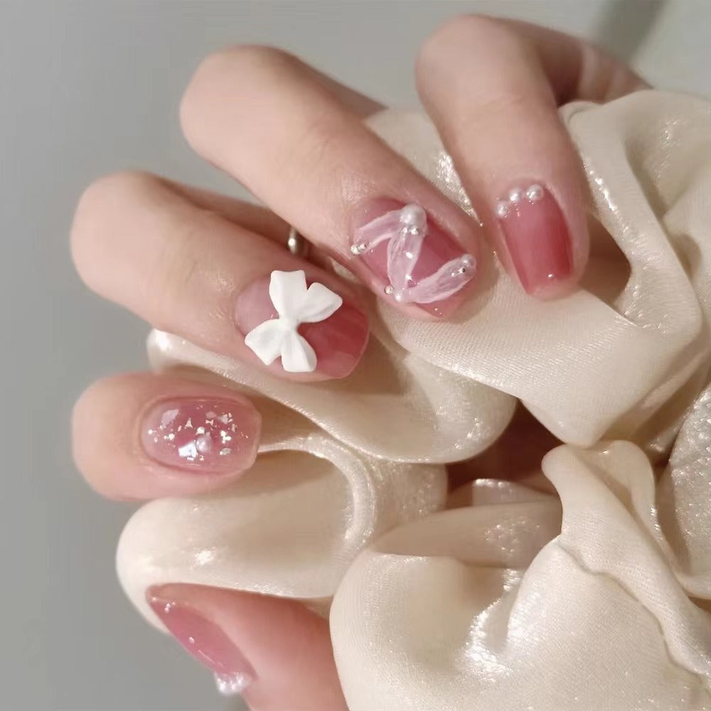 Glamouröse Nagelkunst mit Perlen- und Schleifenakzenten Karnz
