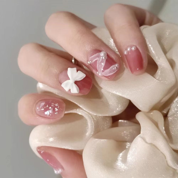 Glamouröse Nagelkunst mit Perlen- und Schleifenakzenten Karnz