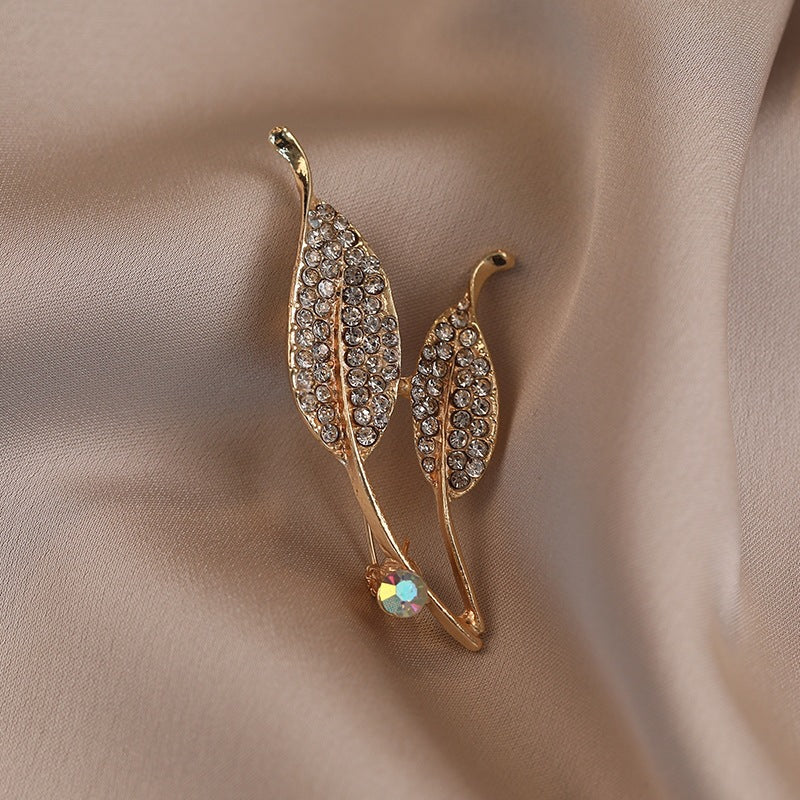 Elegante Brosche mit Blattform und Kristallen Karnz
