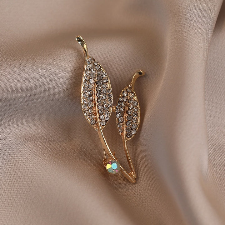 Elegante Brosche mit Blattform und Kristallen Karnz