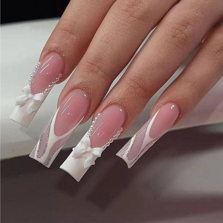 Elegante Kunstnägel mit Perl- und Schleifenverzierungen Karnz