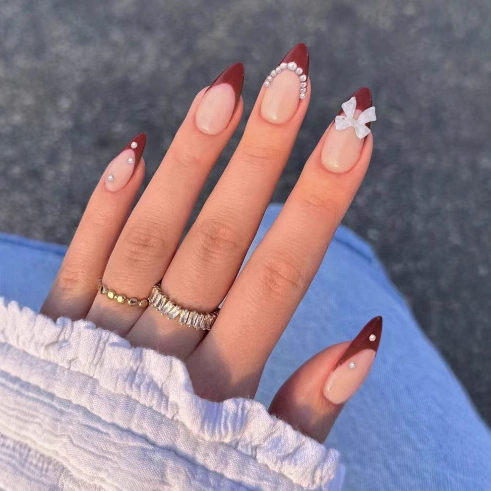Kunstnagelset mit glamourösen Strass- und Schleifenverzierungen Karnz