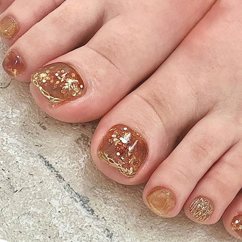 Kunstvolle Fußnagelgestaltung mit Glitzer und goldenen Akzenten Karnz