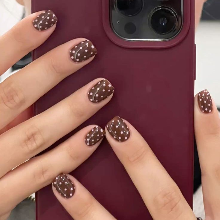 Kunstnagelset mit stilvollen Schokoladenflecken und eleganten Punkten Karnz