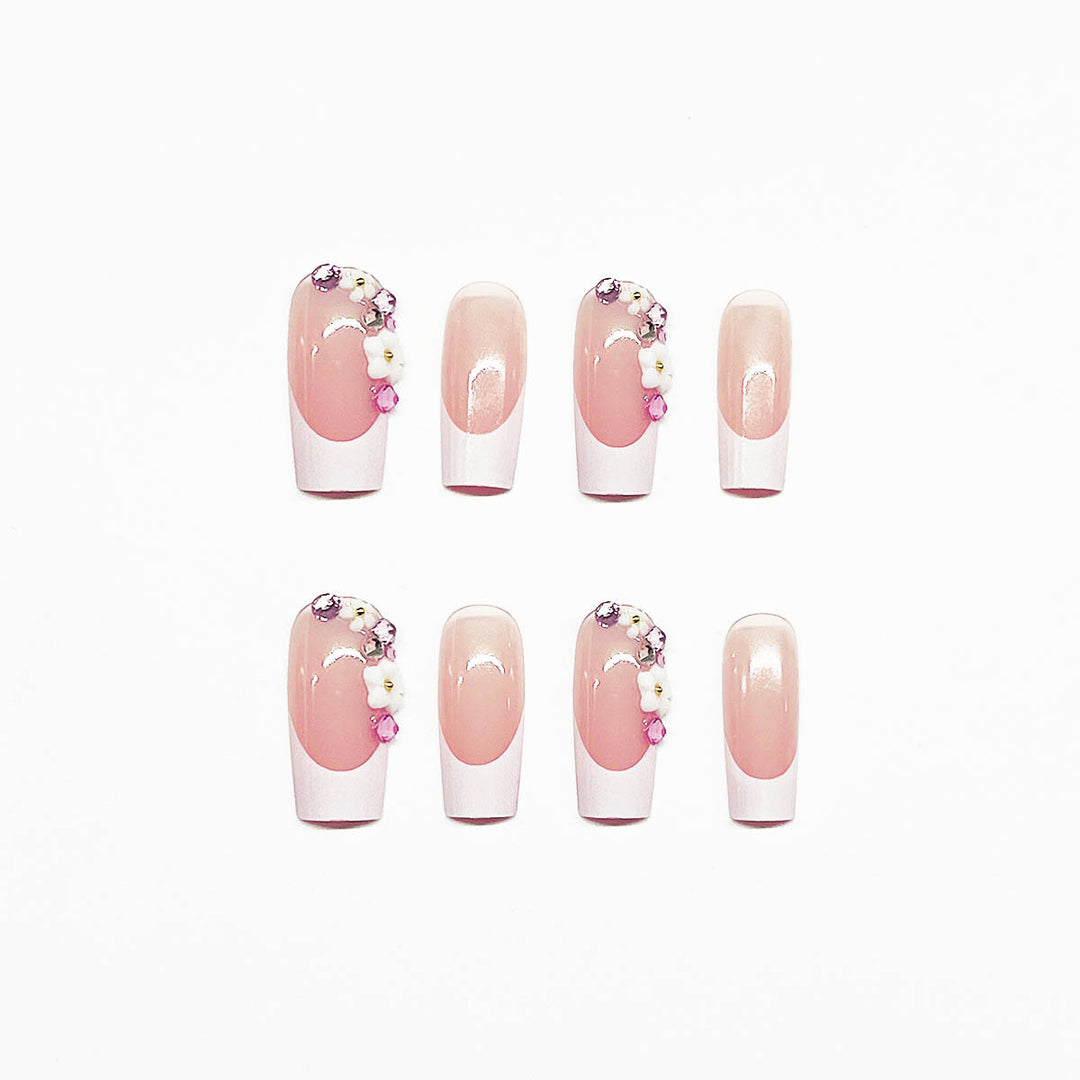 Kunstnagelset mit eleganten Blumendekoren und transparentem Finish Karnz