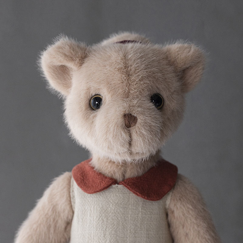 Handgefertigter Plüsch-Teddybär mit Leinenkleid und gestickten Merkmalen
