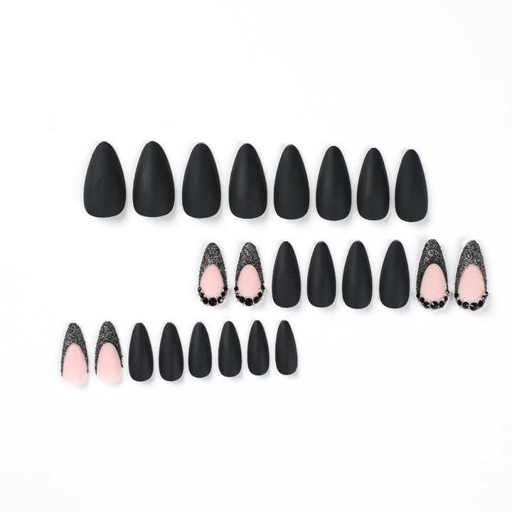 Kunstvolle Stiletto-Nägel mit elegantem Schwarz-Design und Glitzerakzenten Karnz