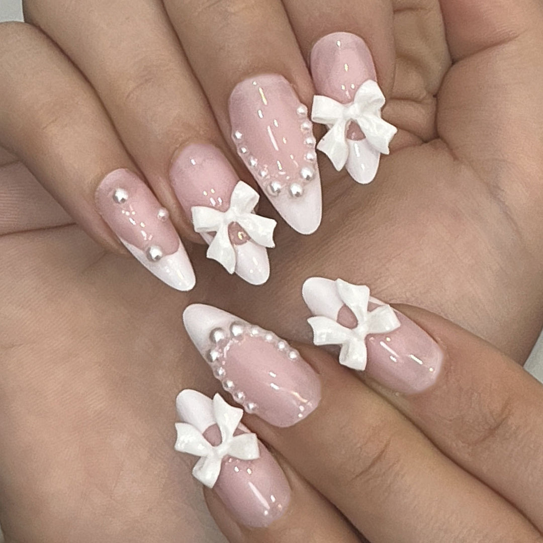 Dekorative Press-On-Nagelkunst mit Schleifenakzenten