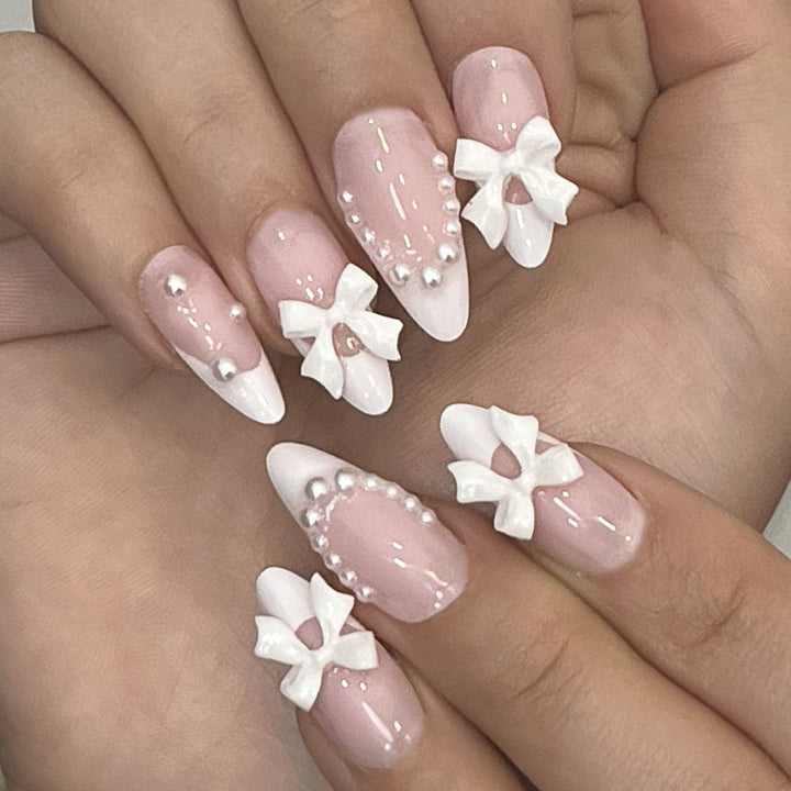 Dekorative Press-On-Nagelkunst mit Schleifenakzenten