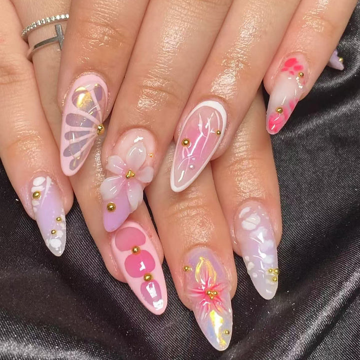 Kunstvolle Nagelverlängerungen mit floralen Mustern und Strassverzierungen Karnz