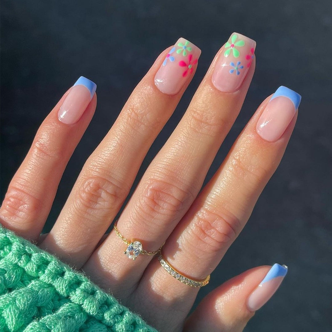 Kunstnagelset mit bunten Blüten und kreativem French-Design Karnz