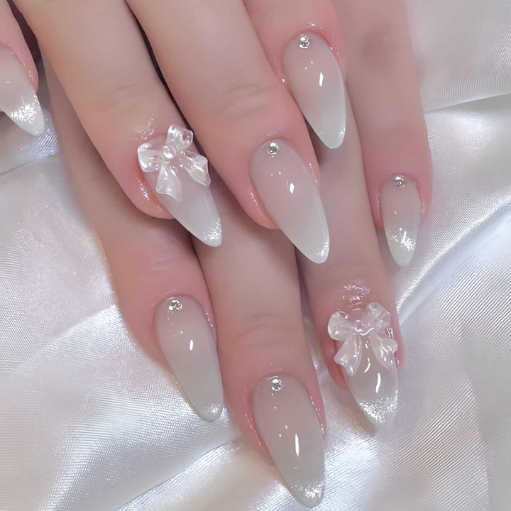 Elegante stilettoförmige Press-On Nägel mit dekorativen Schleifenakzenten Karnz