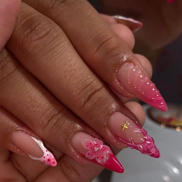 Kunstvolle Stiletto-Nägel mit floralem Design und Glitzerakzenten Karnz
