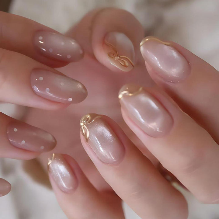 Kunstnagelset mit schimmernden Akzenten und eleganten Goldverzierungen Karnz